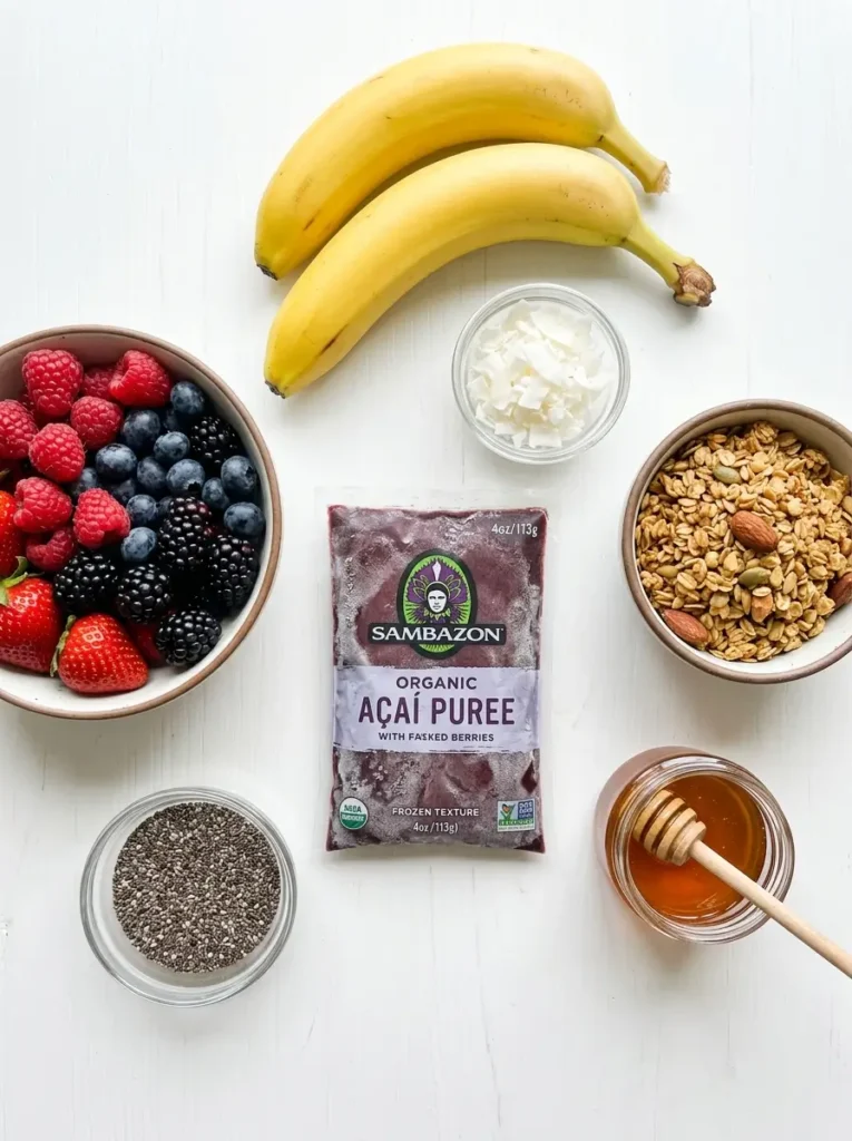 Overhead flat lay, frozen acai puree packet centred, two ripe bananas, bowl of mixed fresh berries, small bowl of granola, shredded coconut, chia seeds, jar of honey, clean white background, soft even natural light